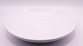 A plate and a corn ring are placed on white background video 4k