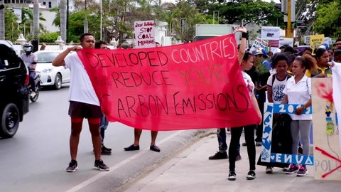 Dili , Timor-Leste - 09 24 2019: People gathering, marching and holding developed countries reduce your carbon emissions sign. Climate change march in capital Dili, Timor Leste, Southeast Asia.
