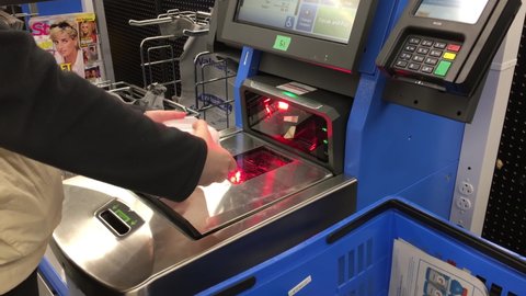 COQUITLAM , British Columbia , Canada - 05 13 2016: Coquitlam, BC, Canada - May 13, 2016 : Close up of woman paying for foods at self-check out counter inside Walmart store