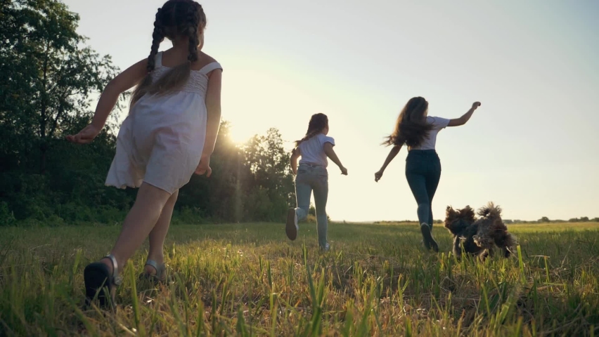 Happy family of children. Children run on green fresh grass. happy children group have fun in nature in park outdoors with a pet. pet dog run along with a group of cheerful kids. Royalty-Free Stock Footage #1078231235