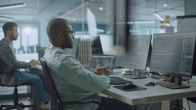 Office: Energetic Black IT Programmer Puts on Headphones Starts Working on Desktop Computer. Male Website Developer, Software Engineer Developing App, Video Game. Listening to Podcast, Music