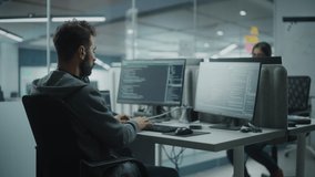 Diverse Office: IT Programmer Working on Desktop Computer. Male Specialist Creating Innovative Software Engineer Developing App, Program, Video Game. Terminal with Coding Language. Over Shoulder