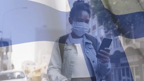 Animation of flag of finland waving over woman in face masks. global covid 19 pandemic and healthcare services concept digitally generated video.