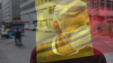 Animation of flag of belgium waving over man in face masks. global covid 19 pandemic and healthcare services concept digitally generated video.