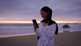 Somali-American woman checking her social media at a beach in Malibut. - Powered by Shutterstock - Get 15% off with code: PIKWIZARD15
