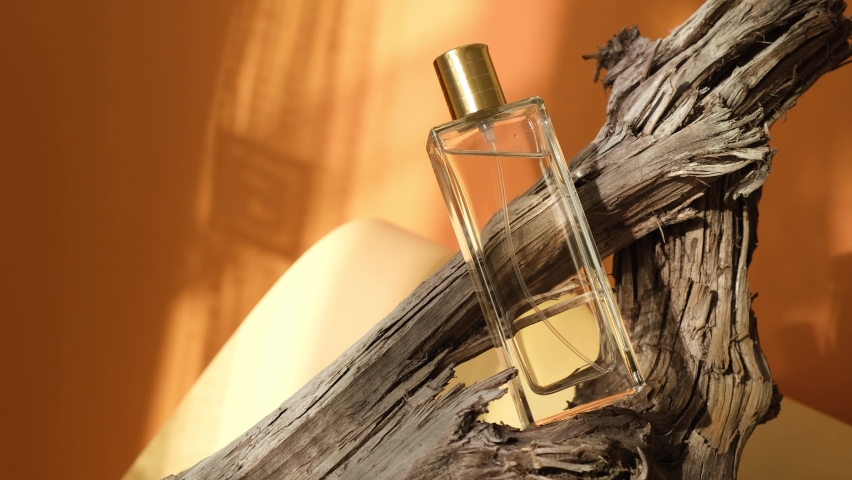 Glass bottle of perfume on driftwood, natural shade background | Shutterstock HD Video #1078261103