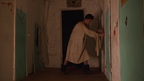Horror acting - an aggressive man in a straitjacket trying to broke in the room in mental hospital