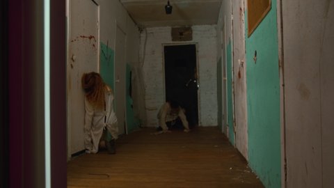 Horror acting - man and woman going crazy in the corridors of scary bloody mental hospital