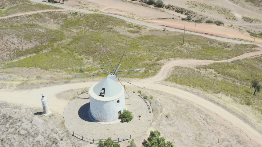 Drone flight over an old traditional Portuguese windmill on a mountain, overviewing the landscape around.