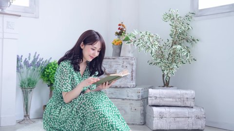 Young asian woman reading a book in the room.
