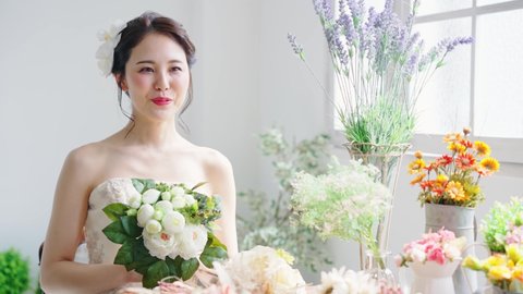 Asian bride surrounded by flowers. Bridal concept. Wedding photo.