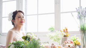 Asian bride surrounded by flowers. Bridal concept. Wedding photo.