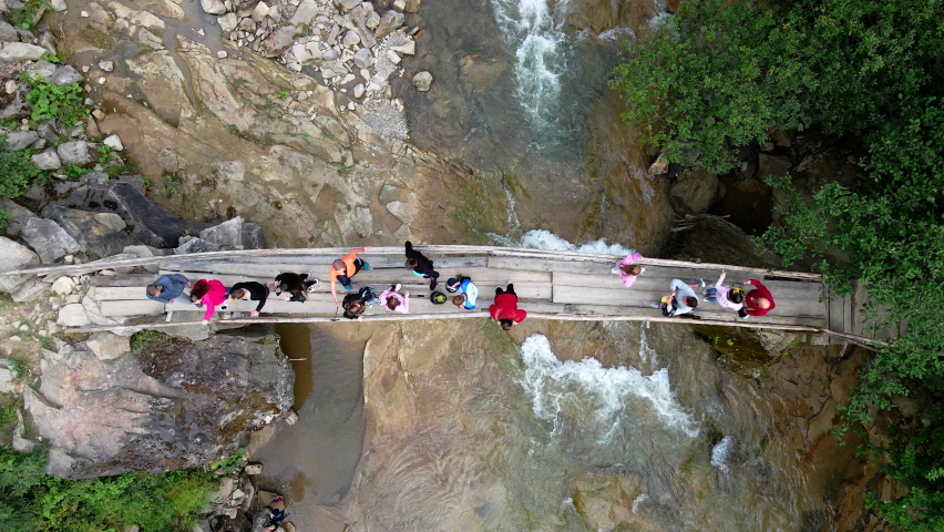 aerial view of people at the bridge across mountain river copy space