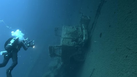 Scuba diver photographer shots truck on the shipwreck Swedish ferry MS Zenobia. Wreck diving. Mediterranean sea, Cyprus
