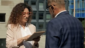 Business team man and woman working together outside. Boss and assistant holding tablet taking notes. Boss and secretary having consultation outdoor. - Powered by Shutterstock - Get 15% off with code: PIKWIZARD15