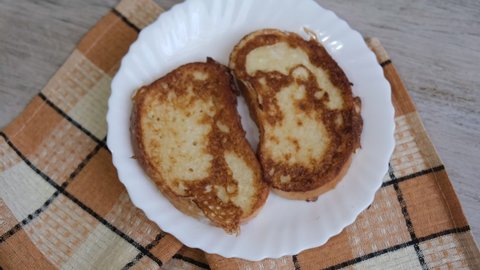 Bread toast dish made of fried sliced bread soaked in eggs and milk. Soft breakfast recipe. European meal. Homemade fried toast.