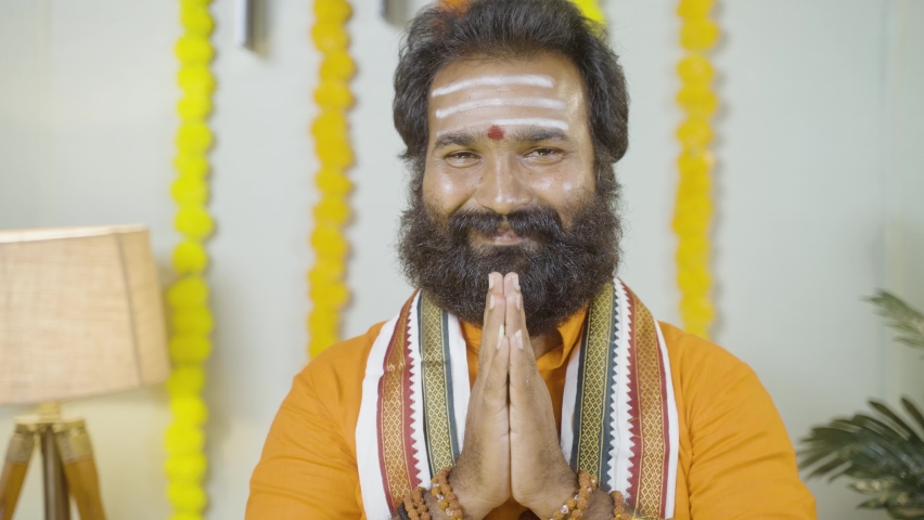 Beard Indian man or holy guru with rudraksha mala preaching holy vedas by looking into camera - concept of religious teachings by monks or priests at temple