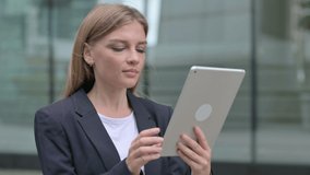 Young Businesswoman Talking on Video Call on Tablet while Walking on the Street 