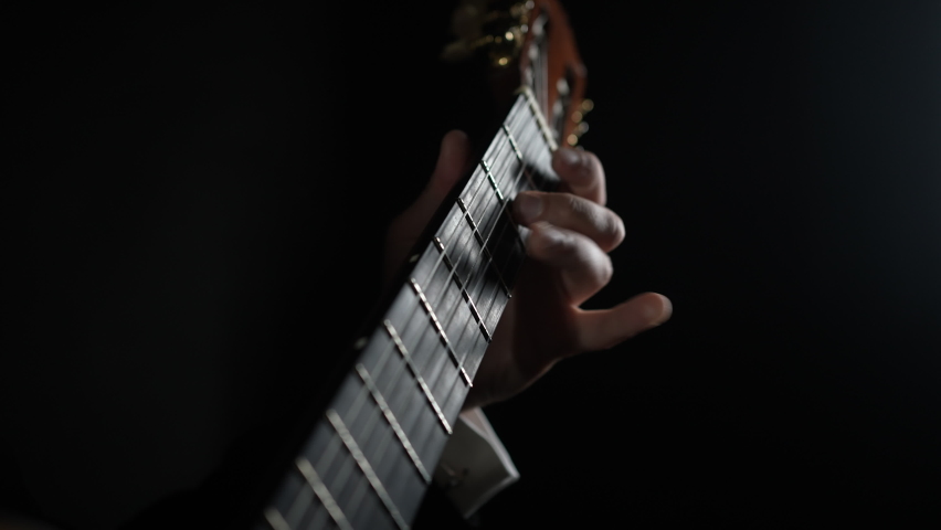 Close up focus on male hands on guitar fingerboard, young man learning chords, self-educating playing string instrument. Professional musician performing melody, showing excellent musical technique. Royalty-Free Stock Footage #1078295774
