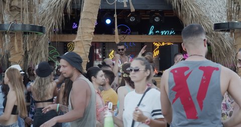 Sozopol, Bulgaria, August 2021 - Dj playing music at beach bar with crowd dancing and having fun - summer holiday