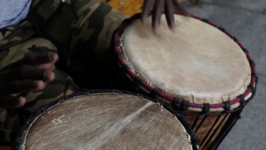 African plays African drum on the street