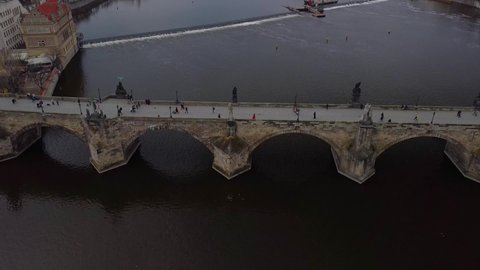 Aerial view of Prague Charles Bridge over Vltava river at cloudly sunset. Old Town of Prague, Czech Republic.