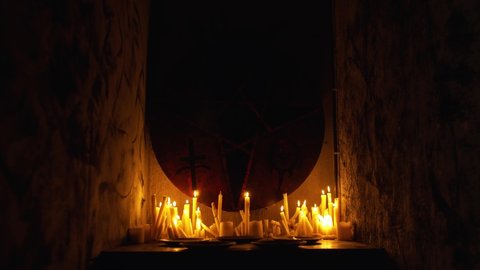 Occult stent with pentagram surrounded by candles in the dark