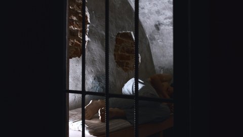 Horror acting - a shirtless man struggling in the prison cell