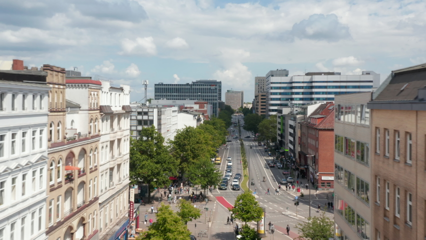 Forwards fly above wide street lined with modern buildings. Free and Hanseatic City of Hamburg, Germany