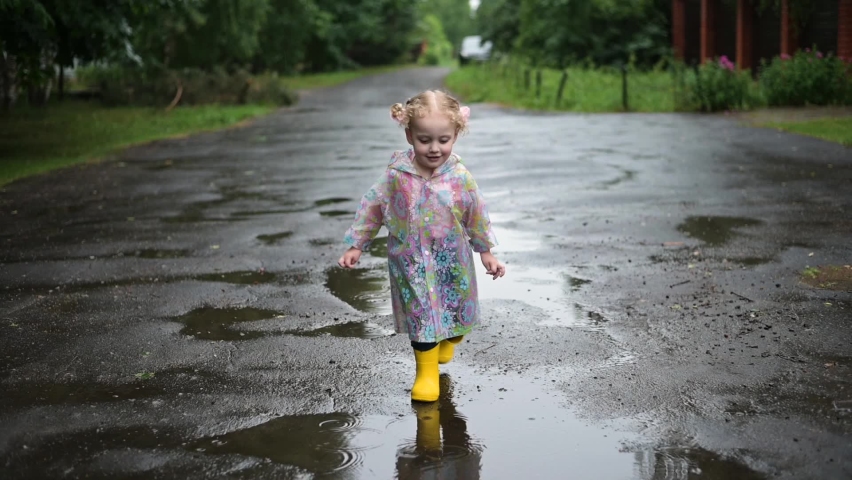The little girl runs on a better rainy day. Childhood and good mood Royalty-Free Stock Footage #1078313678