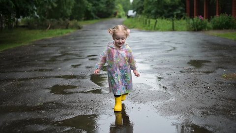 The little girl runs on a better rainy day. Childhood and good mood