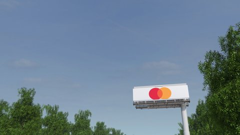 MOSCOW, RUSSIA - CIRCA 2020. Airplane flies over billboard with Mastercard logo