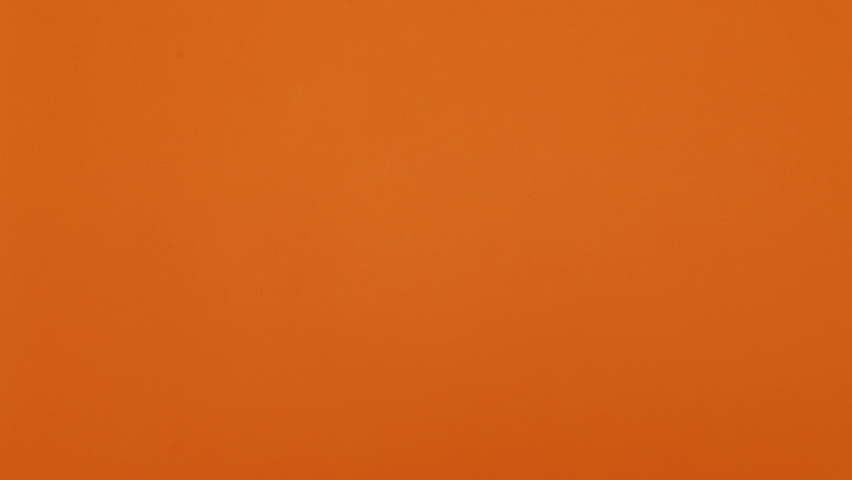 Happy Halloween. A garland of pumpkins appears on an orange background. Pumpkins with a smile and eyes hang from a rope. Then black bats appear. Stop motion.