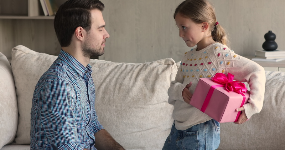 Loving daughter gives to daddy gift box congratulates him on birthday. Overjoyed man receive from caring kid present feels amazed, enjoy surprise, hug child express gratitude. Happy Father Day concept Royalty-Free Stock Footage #1078337945