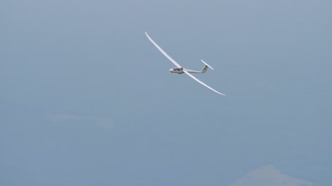 Thiene, Italy JULY, 8, 2021 Glider landing with the spoilers open and a green mountain in the background. Schempp-Hirth Duo Discus