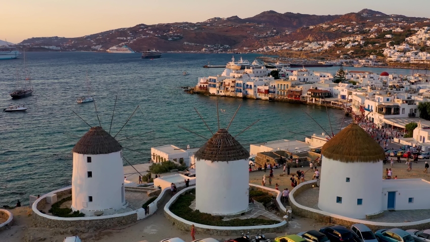 Aerial view through the famous windmills above Mykonos town, Cyclades, Greece, to the Little Venice district during summer sunset time Royalty-Free Stock Footage #1078344695
