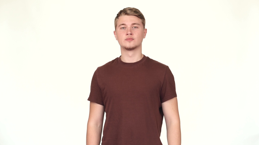 Footage of young causal man standing over white background and thinking | Shutterstock HD Video #1078345079
