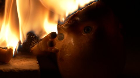 SYDNEY, NSW, AUSTRALIA. FEBRUARY 21 2020. Eyes of a doll looking towards camera whilst burning, with sound.