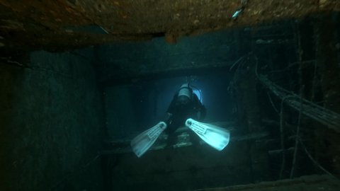 MEDITERRANEAN SEA, CYPRUS - AUGUST, 2021: Scuba diver swims inside of the shipwreck Swedish ferry MS Zenobia. Wreck diving. Mediterranean sea, Cyprus