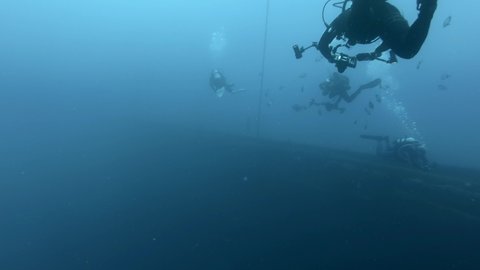 MEDITERRANEAN SEA, CYPRUS - AUGUST, 2021: Scuba divers swims on the shipwreck Swedish ferry MS Zenobia. Wreck diving. 