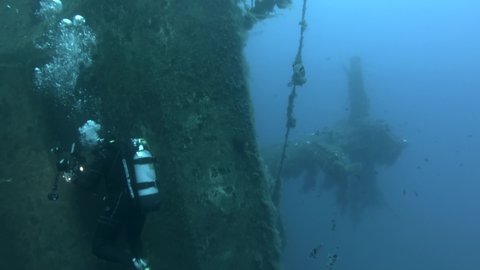 MEDITERRANEAN SEA, CYPRUS - AUGUST, 2021: Scuba diver swims inside of the shipwreck Swedish ferry MS Zenobia. Wreck diving.  