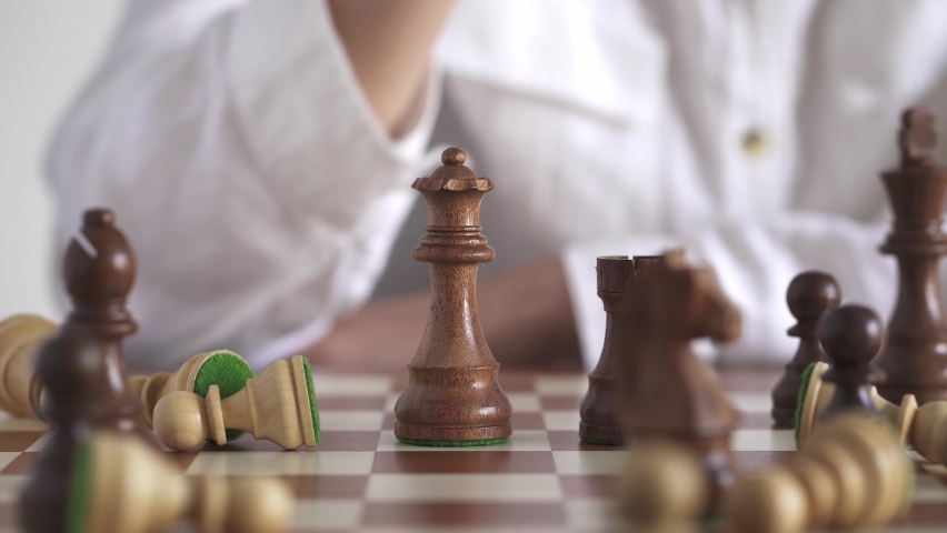 Business woman in a white shirt plays chess. Queen's move. Close-up of a woman's hand moving a chess piece. Competition, competition of business ideas and strategy ideas. Black and white classic.
 Royalty-Free Stock Footage #1078364831