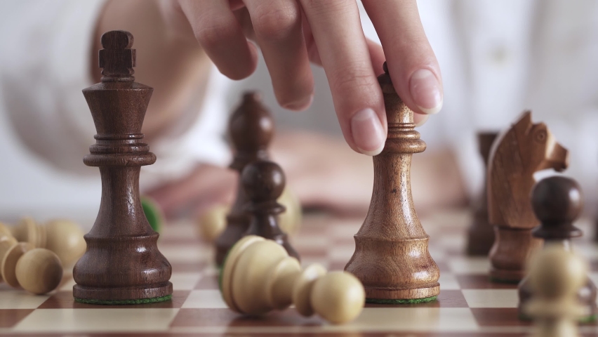 Wood chessboard during game. Queen's move. Movement of queen's piece on chessboard. Woman plays wooden chess. Person makes move in chess game. Concept of successful business woman, strategic thinking. Royalty-Free Stock Footage #1078364840