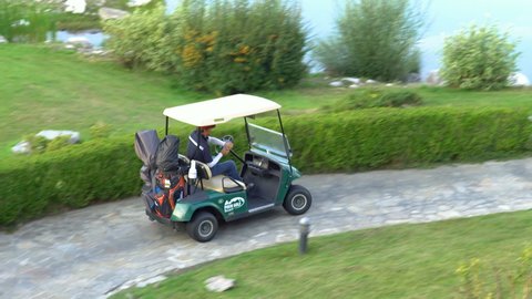 Bansko, Bulgaria - 12 May, 2021: Professional golfers are driving golf cars to explore the golf course.