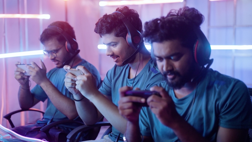 Team of Video gamers with headphones happy about winning the match while playing video game on mobile phone during online live streaming gaming competition or tournament league Royalty-Free Stock Footage #1078379402