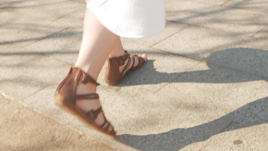 A woman in sandals and a summer dress climbs the stairs, a sunny day. Old Town Odessa. Slow motion, the tourist climbs to the top. Rest, travel, climb up. beautiful footage walk and city tour
