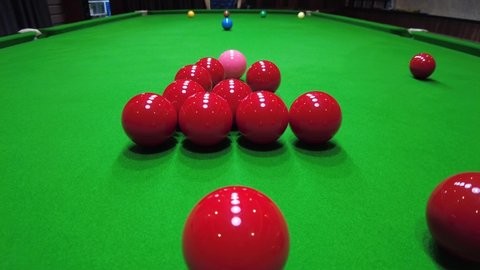 Slow-motion the starting shot of snooker game, cue ball striking the red balls, indoor sport concept 