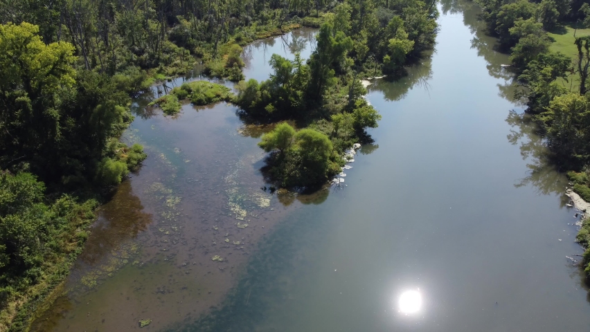 Flying down to tree on river in ohio with drone