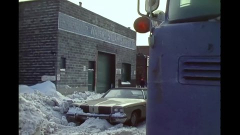 CIRCA 1977 - Men of the 20th Engineer Brigade use heavy machinery to remove snow after a blizzard in downtown Buffalo, New York.