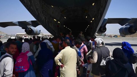 CIRCA 2021 - Afghan refugees attempt to board a U.S. C-17 Globemaster at Hamid Karzai Airport in Kabul Afghanistan during the American evacuation.